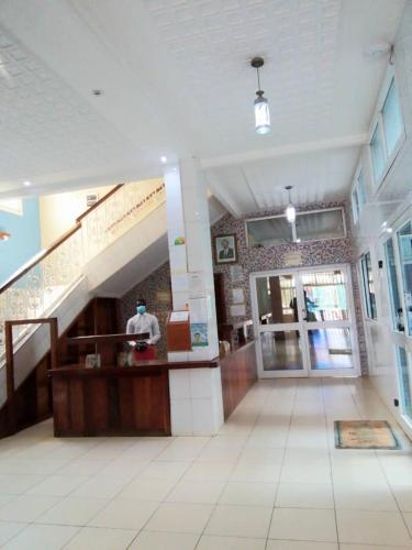 een lobby van een gebouw met een trap en een persoon bij Adamaoua Hôtel Plus in Ngaoundéré