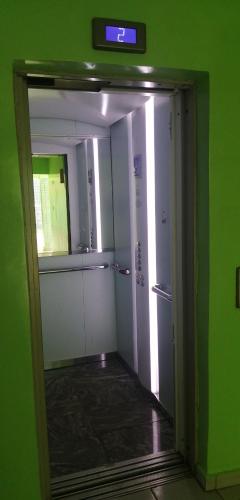 una habitación con una pared verde y una puerta con reloj en Adamaoua Hôtel Plus, en Ngaoundéré