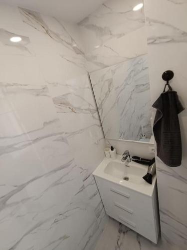 a white bathroom with a sink and a mirror at Nuevo apartamento cerca del mar in Denia