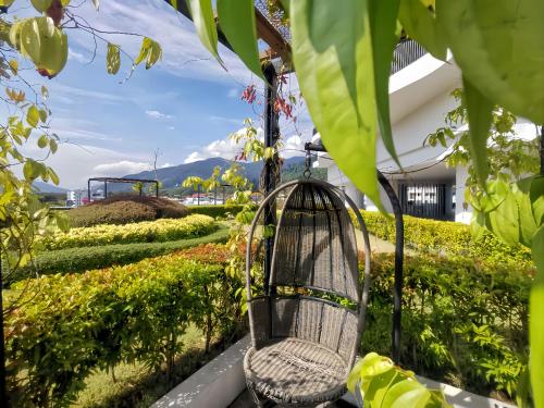 una jaula de pájaro colgando de un árbol en un jardín en The Landmark Penang by Stay Premium, en Tanjong Tokong