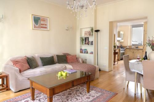 un salon avec un canapé et une table dans l'établissement La Lumiere Eiffel Walk to Tower, à Paris