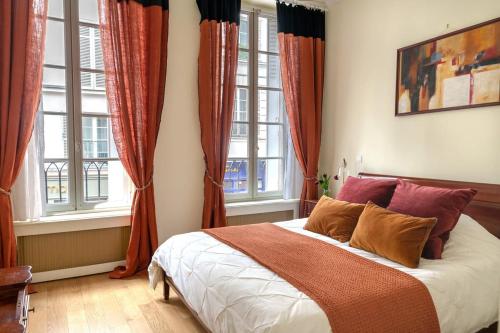 - une chambre avec un lit doté de rideaux rouges et de fenêtres dans l'établissement La Lumiere Eiffel Walk to Tower, à Paris