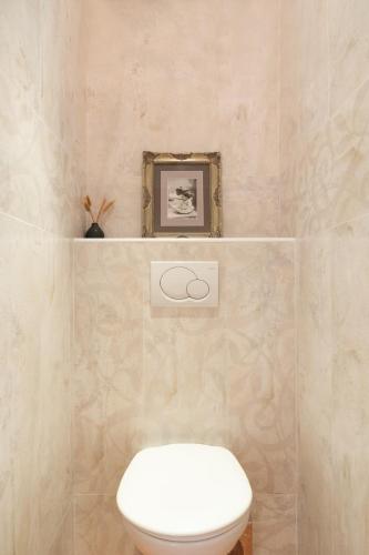 une salle de bain avec toilettes et un tableau au mur dans l'établissement La Lumiere Eiffel Walk to Tower, à Paris