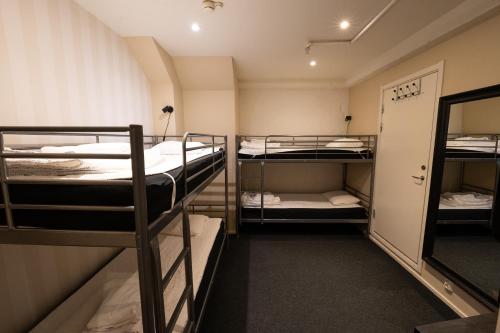 a room with three bunk beds and a mirror at Stockholm Hostel in Stockholm