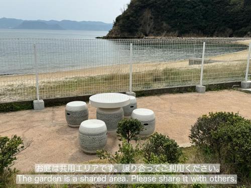 uma área de piquenique com vista para a praia em Vacation House YOKOMBO em Naoshima