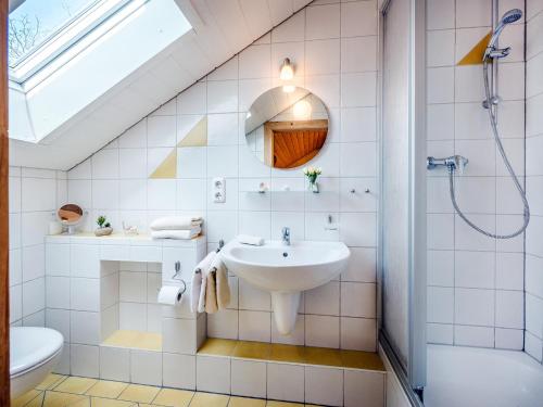 La salle de bains est pourvue d'un lavabo et d'une douche. dans l'établissement Panoramahof Stief, à Taching am See
