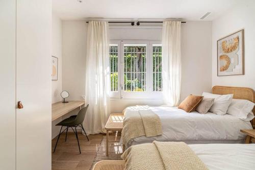 Un dormitorio con dos camas y un escritorio y una ventana. en Vista Serena, en Sant Cugat del Vallès