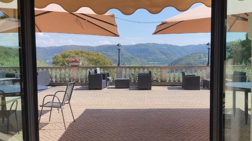 a patio with tables and chairs and mountains in the background at Locanda degli Ulivi in Arcugnano