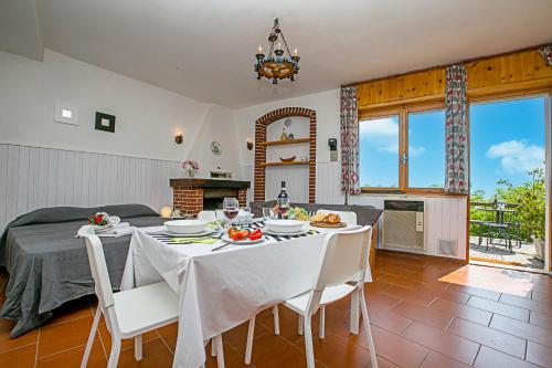 uma sala de jantar com uma mesa com toalhas e cadeiras brancas em Tremosine Wonderful Lake View 1 em Tremosine Sul Garda