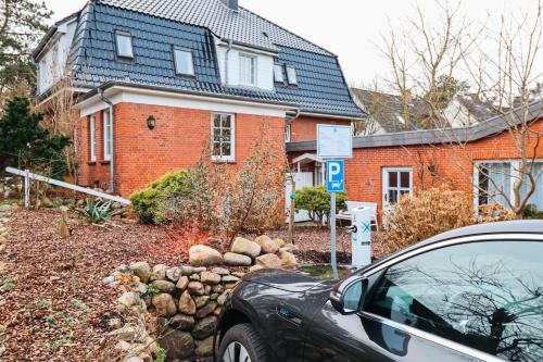 a car parked in front of a brick house at Hotel kleine Auszeit - Adults Only in Sankt Peter-Ording