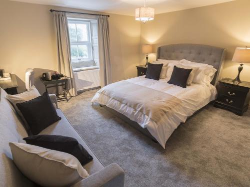 a bedroom with a large bed and a couch at New Crown Inn in Appleby