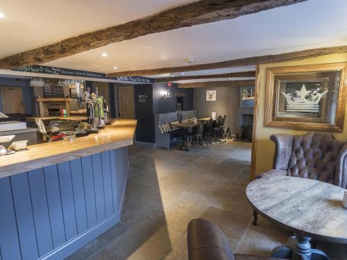 a bar in a restaurant with a table and chairs at New Crown Inn in Appleby