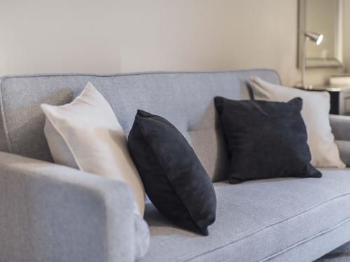 a gray couch with black and white pillows on it at New Crown Inn in Appleby