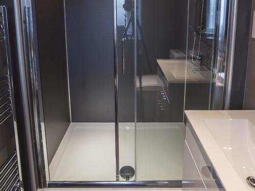 a glass shower in a bathroom with a sink at New Crown Inn in Appleby