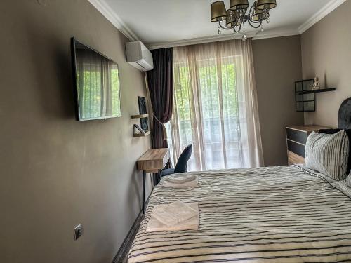 1 dormitorio con cama y ventana en APARTMENT ROYAL ASENOVGRAD en Asenovgrad