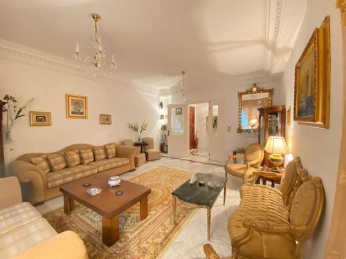 a living room with a couch and a table at The Epitome of Luxury: S+2 Apart & Parking Ennasr2 in Ariana