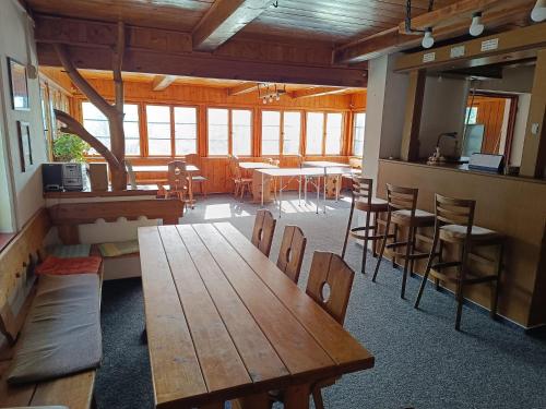 Habitación con mesas de madera y sillas en un edificio en Chata Florian en Srní