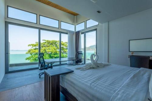 a bedroom with a large bed and large windows at Do You Want Luxury Sea views With Beach Access in Ban Saiyuan (1)