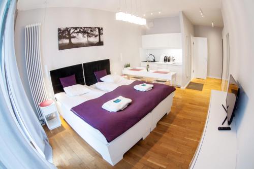 sypialnia z dużym łóżkiem i fioletowym kocem w obiekcie Triton Apartments in Warsaw w Warszawie