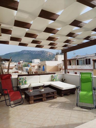 a patio with a couch and chairs and a table at Terra Sinus Beautiful Suite in Terrasini