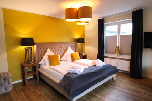 a bedroom with a bed with two towels on it at Das Frühstückshotel Sankt Peter-Ording in Sankt Peter-Ording