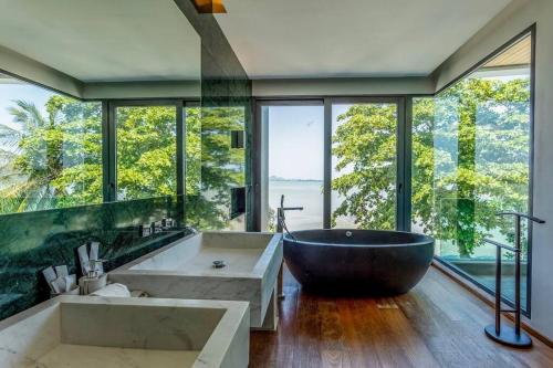 La salle de bains spacieuse est pourvue d'une grande baignoire et de grandes fenêtres. dans l'établissement Do You Want Luxury Sea views With Beach Access V38, à Ban Saiyuan (1)