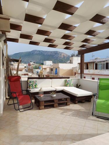 a patio with a couch and chairs and a table at Terra Sinus Beautiful Suite in Terrasini