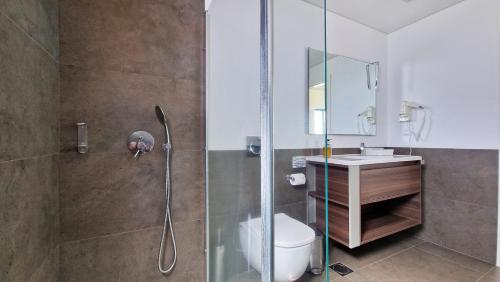 Un baño con ducha, inodoro y lavabo. en Eden Sun - A Modern Luxury Villa with a Panoramic View, en Prazeres