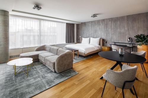 プラハにあるKarlin Residence by TKCのベッド、ソファ、テーブルが備わるホテルルームです。