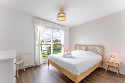une chambre blanche avec un lit et une fenêtre dans l'établissement Le Sully - Joli duplex centre de Nantes, à Nantes
