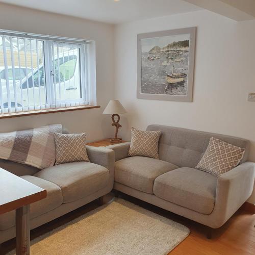 a living room with a couch and a table at Chynoweth Mews in Newquay