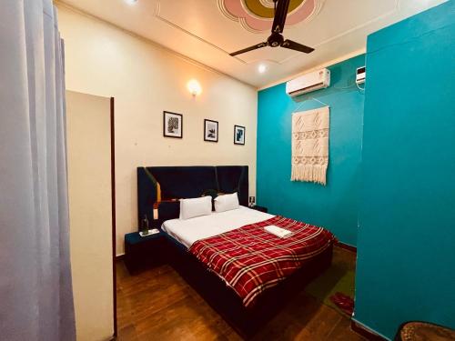 um quarto com uma cama e uma parede azul em Stayble Homestay em Dehradun