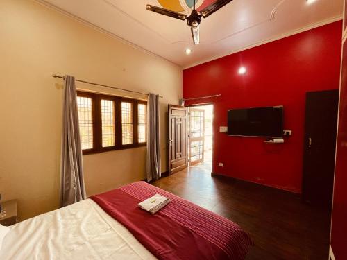 a bedroom with a bed with a red wall at Stayble Homestay in Dehradun