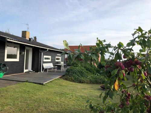 a house with a porch and a bench on a yard at Funen Cottage With Fantastic Sea View, in Assens