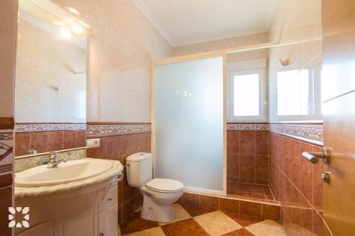 a bathroom with a toilet and a sink and a window at Villa Paula by Abahana Villas in Benissa