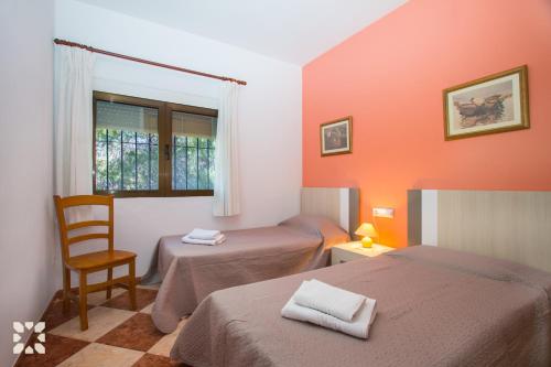 a room with two beds and a chair and a mirror at Villa Paula by Abahana Villas in Benissa