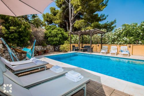 a swimming pool with lounge chairs and an umbrella at Villa Paradise by Abahana Villas in Calpe