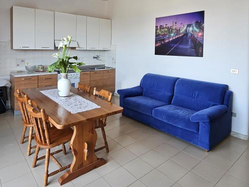 salon z niebieską kanapą i stołem w obiekcie La tua vacanza in Salento w mieście Porto Badisco