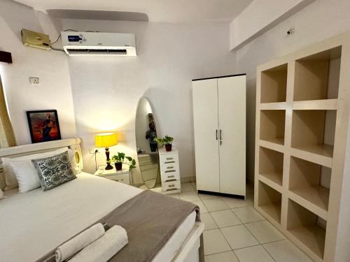 a bedroom with a bed and a dresser and a mirror at La- Maria's By The Beach Goa in Benaulim