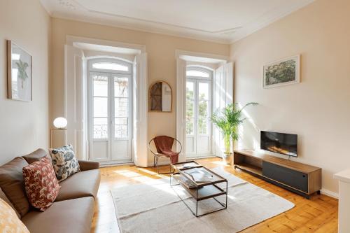 a living room with a couch and a tv at Santa Maria Rooms and Apartments in Setúbal