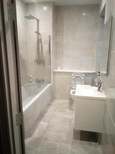 a bathroom with a tub and a sink and a toilet at Happy home in Brimington