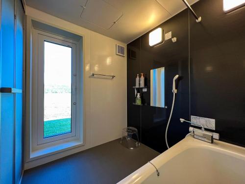 a bathroom with a bath tub and a window at FLEXWORK tawa - Vacation STAY 75198v in Teshikaga
