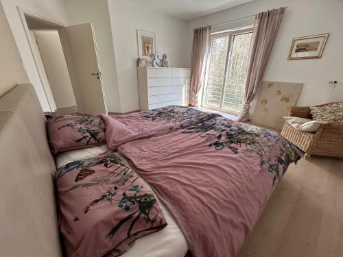 a bedroom with a pink bed and a window at Ferienhaus am Waldrand in Riedenburg