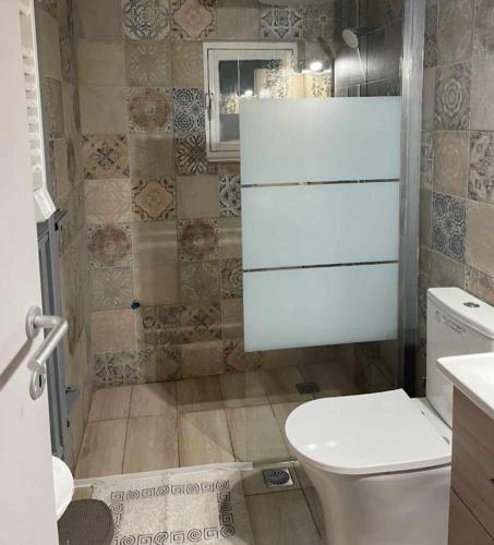 a bathroom with a white toilet and a sink at Zoe garden home in Spáta