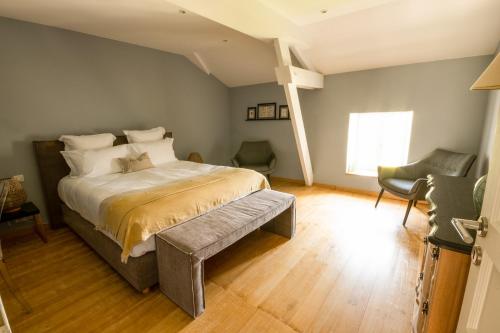 een slaapkamer met een bed, een stoel en een raam bij Chambre Flori - Lavy in Saint-Pierre-de-Côle