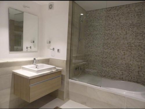 a bathroom with a sink and a shower and a tub at Cairo in El Alamein
