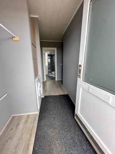 an empty hallway of an office with a door open at Cabin in Faukás, west part of Iceland - Birta Rentals in Fossatún