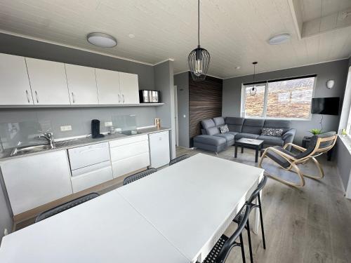 a kitchen and living room with a table and a couch at Cabin in Faukás, west part of Iceland - Birta Rentals in Fossatún