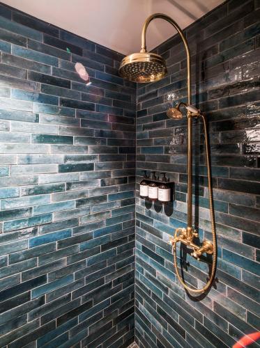 a bathroom with a blue brick wall with a shower at Villa Vågå - by Classic Norway Hotels in Vågåmo