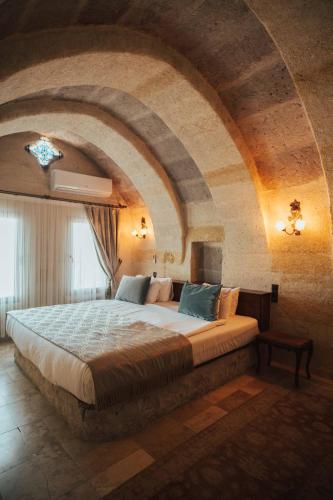 a bedroom with a large bed in a stone room at Hu of Cappadocia - Special Class in Uchisar